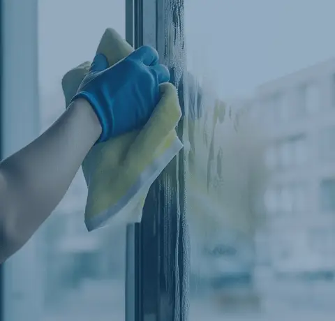 Persona limpiando cristal, imagen representativa del sector Facility Services gestionado con ERP AHORA y consultoría tecnológica de Stratic