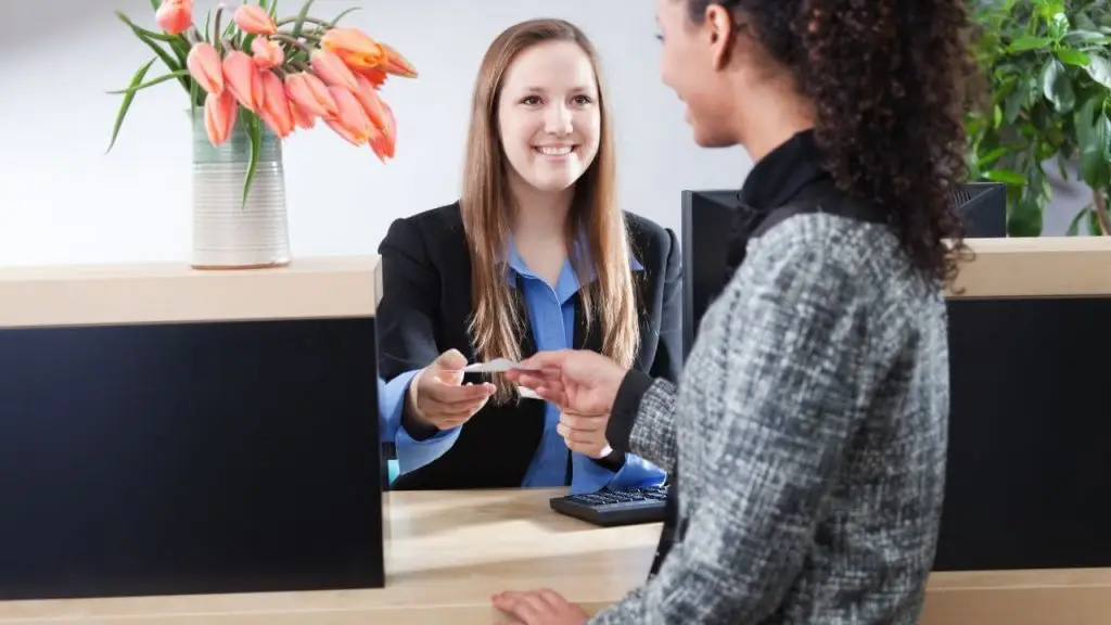 Recepcionista atendiendo a cliente durante conciliación bancaria