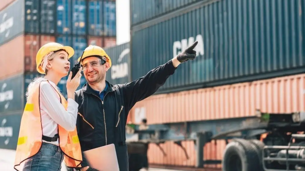 Trabajadores en puerto gestionando contenedores con ayuda de un ERP para logística y transporte, solución digital implementada por Stratic