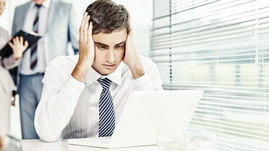 Empleado estresado frente al ordenador, símbolo de los errores comunes en la gestión TI que afectan a muchas empresas, según Stratic