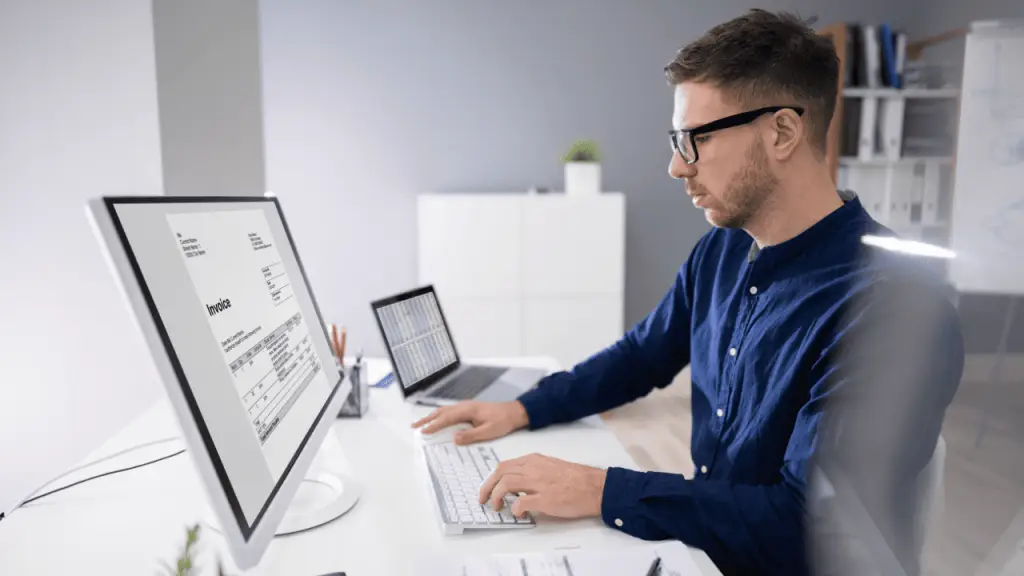 Profesional revisando factura digital en oficina mostrando KPIs que mejora la automatización de facturas en una empresa con Stratic