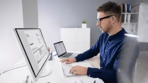 Profesional revisando factura digital en oficina mostrando KPIs que mejora la automatización de facturas en una empresa con Stratic